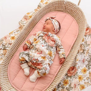 sweet newborn baby girl wearing lottie and lysh floral romper with matching headband and swaddle blanket