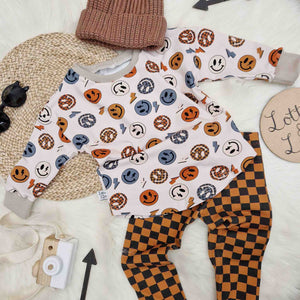 skate inspired toddler outfit by lottie and lysh featuring checkerboard leggings and smile face t-shirt with coordinating brown knitted beanie hat