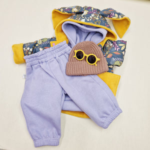 Lottie & Lys Bunny Jacket in floral & mustard. Paired with a lilac hooded tracksuit, orange sunglasses and brown knitted beanie hat