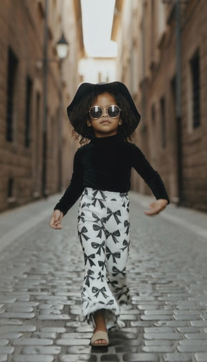 Trendy girl wearing bow print flares walking down the street