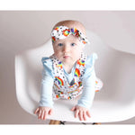 baby girl wearing Lottie & Lysh organic rainbow print dungarees
