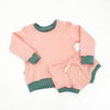 pink child and baby shorts with green trim and coordinating sweatshirt by lottie and lysh