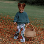 abstract print toddler flared trousers by Lottie & Lysh. Worn by a little girl with auburn hair in an autumnal scene