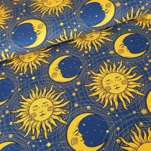 Dark blue jersey fabric with gold sun and moon print design in the style of 90s bedding.