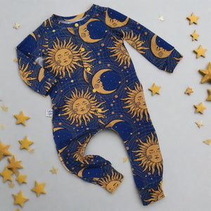 handmade baby romper made with dark blue fabric featuring a 90s inspired sun and moon print in gold