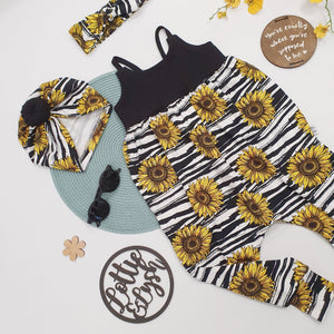 Black and white romper with sunflower detail. Photographed with coordinating accessories