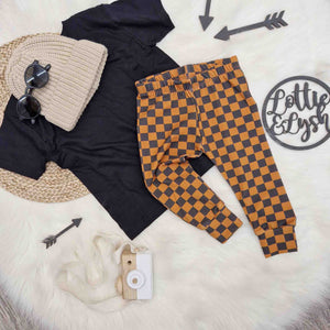 Baby skate clothes. Vintage checkerboard baby and toddler leggings by Lottie & Lysh. Paired with a beige knitted hat and black t-shirt