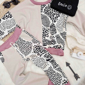 Flat lay featuring Lottie & lysh animal print tracksuit and smiley knitted hat