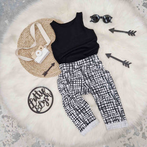 monochrome styled outfit with black and white trousers and black vest