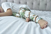 Toddler boy lying on a white and grey bed showcasing the Lottie & Lysh Jungle Jaguar printed leggings