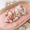 newborn baby girl wearing floral babygrow with coordinating headband and matching swaddle blanket