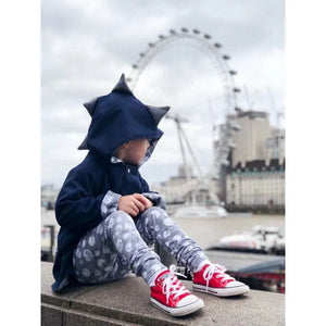 Young boy wearing Lottie & Lysh dinosaur jacket and dino moon baby and toddler leggings watching the london eye from afar