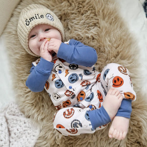 baby boy wearing Lottie & Lysh smile face romper and embroidered hat