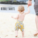 Toddler wearing Lottie & Lysh Mustard Monstera leaf printed bubble shorts 