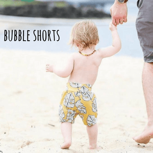 Toddler wearing Lottie & Lysh Mustard Monstera leaf printed bubble shorts 