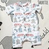Flay lay image of a Lottie & Lysh shortie romper in Beachside. The fabric features images of campervans and beachhuts