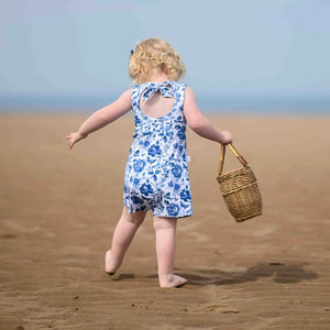 Little girl playing on the beach wearing a Lottie & Lysh blue and white bow back playsuit