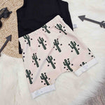 beige kids shorts with green and black leopard print cactus detailing