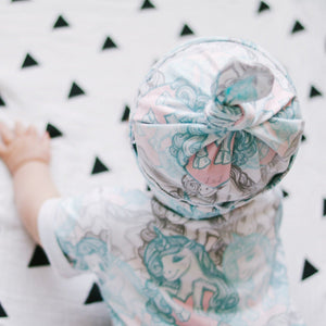 baby girl wearing an organic candy unicorns long leg popper romp with matching jersey baby hat by lottie & lysh